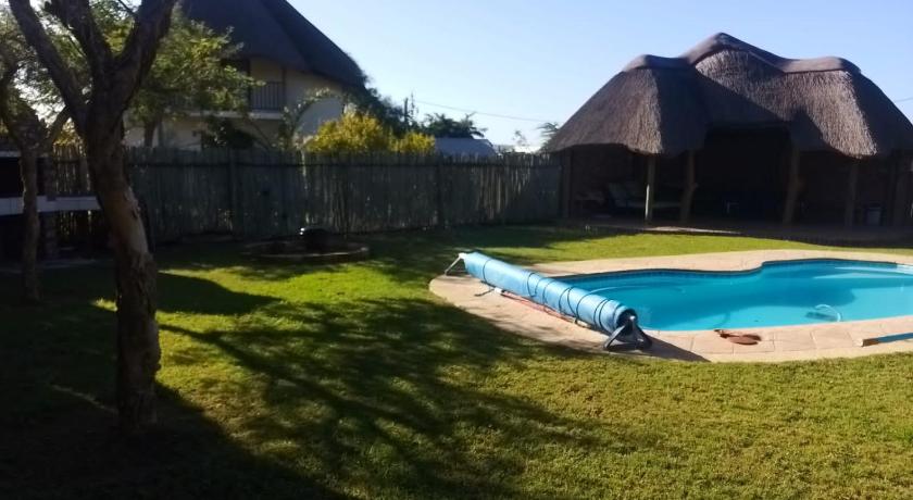 a pool with a lawn chair in front of it, Happy Jackal Guest House in Port Elizabeth