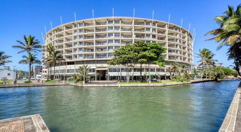 a large building sitting next to a body of water, LUXURY 2 BEDROOM APARTMENT THE SAILS WATERFRONT in Durban
