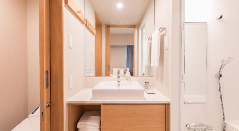 a bathroom with a sink, toilet, and bathtub, Sotetsu Fresa Inn Sendai in Sendai