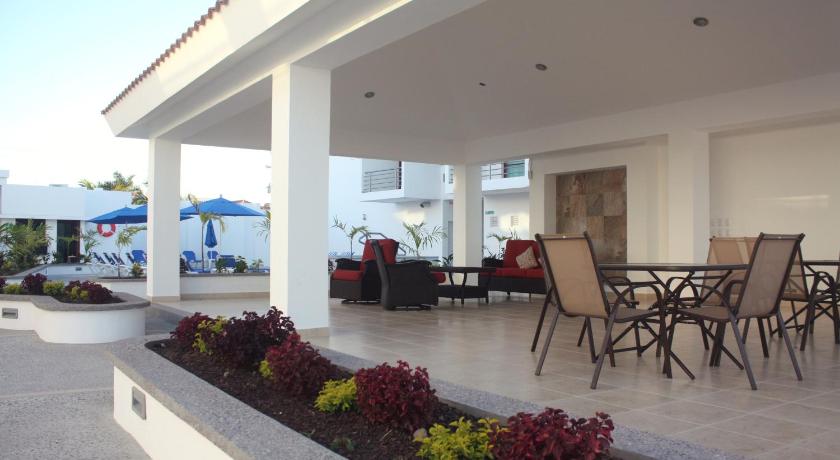 a patio area with chairs, tables and umbrellas, MARENA Suites & Apartments in Mazatlán