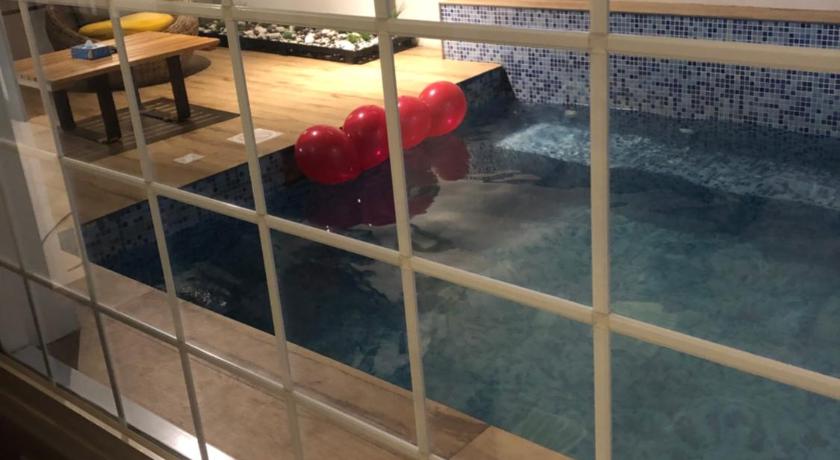 a swimming pool with a large tub and a large mirror, اجنحة بياسة Baeza Suites in Riyadh