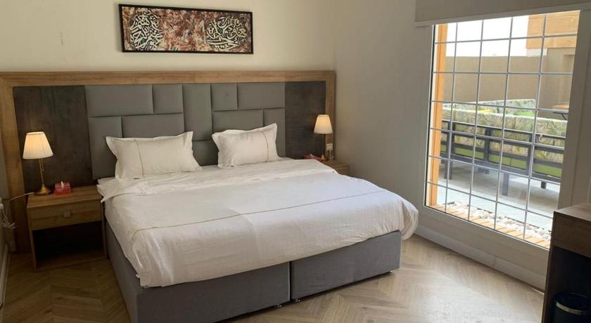 a bedroom with a large bed and a large window, اجنحة بياسة Baeza Suites in Riyadh