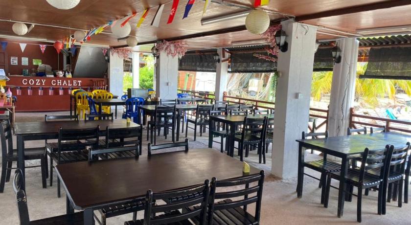 a restaurant with tables, chairs, and tables with umbrellas, Cozy Resort in Perhentian Islands