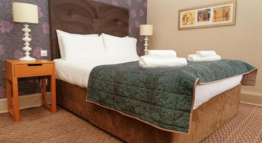 a neatly made bed in a bedroom, The Portpatrick Hotel in Portpatrick