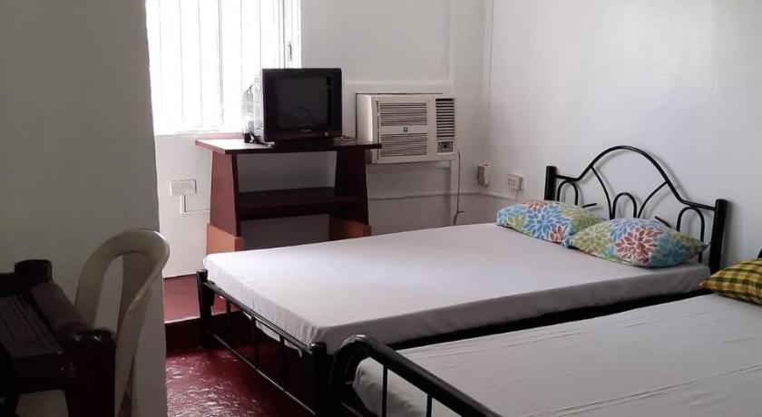 a bedroom with a bed and a desk, Antipolo Budget Hostel in Antipolo