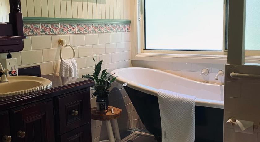 a bathroom with a sink, toilet and bathtub, Telegraph Retreat Cottages in Port Macquarie
