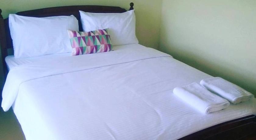 a bed with a white comforter and pillows, OYO 89988 Tambunan Rafflesia Hotel in Kota Kinabalu