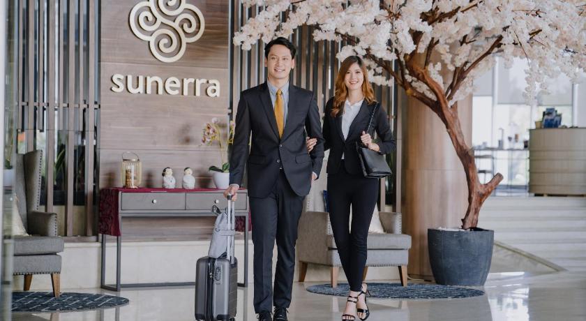 two men and a woman standing in front of a building, Sunerra Antero Hotel Jababeka in Cikarang