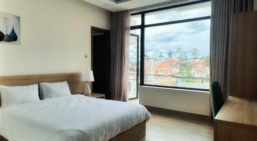 a hotel room with a bed and a window, Q House Dalat in Dalat