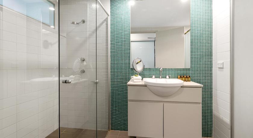a bathroom with a shower, sink, and mirror, Luxury Salt Village Apartments - Holiday Management in Kingscliff