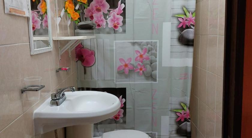 a bathroom with a toilet, sink, and mirror, Alme Hostel in Playa Del Carmen