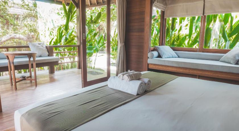 a bedroom with a large bed and a large window, Guava Garden in Lombok