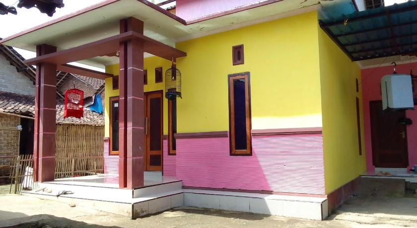 a yellow building with a red door and a blue door, Ijen kingdom guest house in Banyuwangi