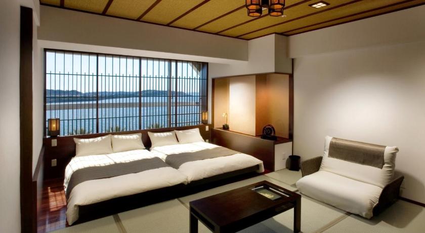 a hotel room with a bed, table, chairs and a balcony, Sago Royal Hotel in Hamamatsu