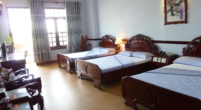 a hotel room with two beds and two night stands, Ca Ty Hotel in Phan Thiet