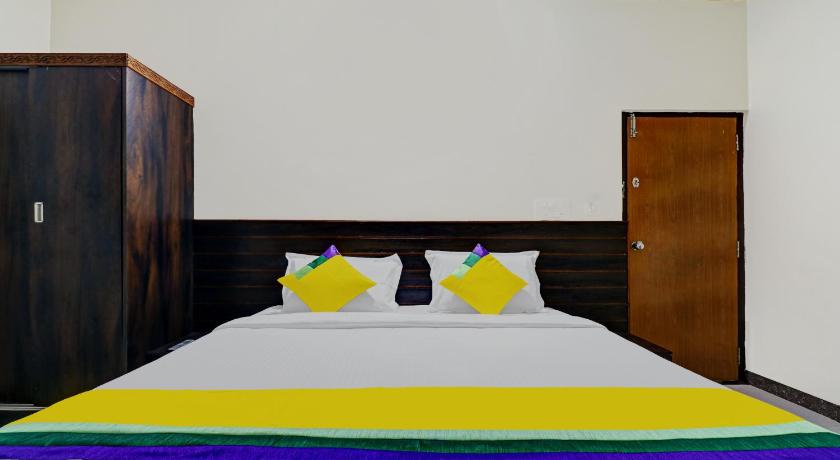 a bed with a blue and white striped bedspread and a blue and white, OYO 10549 Hotel Le Comforts in Coorg