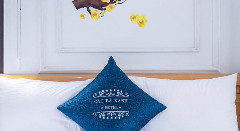 a flower arrangement on a bed in front of a window, Cat Ba Xanh - Green Cat Ba Hotel in Cat Ba Island