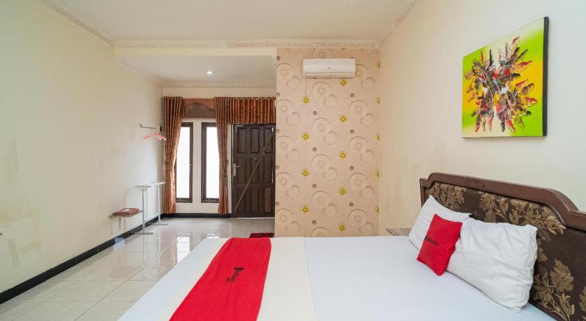 a bedroom with a bed and a painting on the wall, RedDoorz near Bundaran Garuda in Palangkaraya