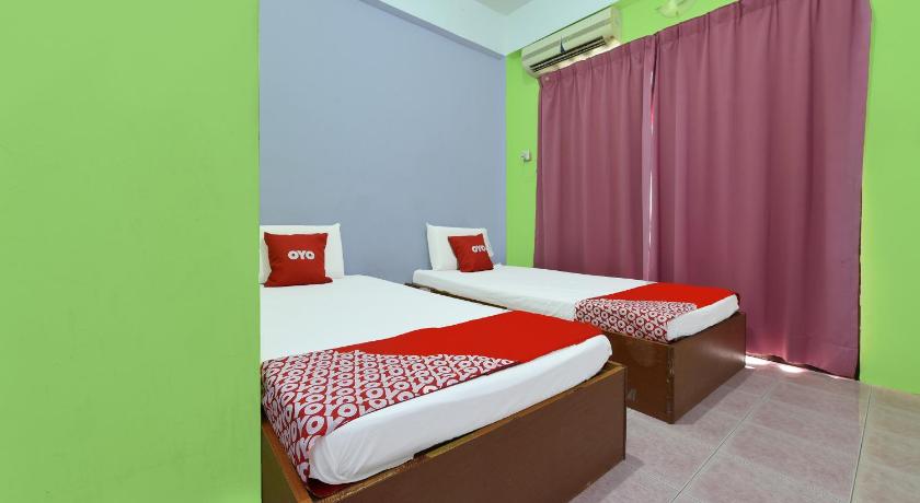 a bed room with a red bedspread and a blue bedspread, OYO 90565 Teresek View Motel in Kuala Tahan