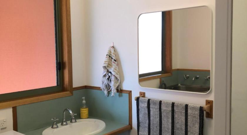 a bathroom with a sink, toilet, and mirror, Seahorse Coastal Villas in Peterborough