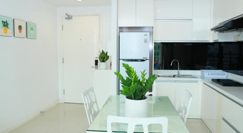 a kitchen with a white table and white cabinets, City By Night Ben Thanh Apartments in Ho Chi Minh City