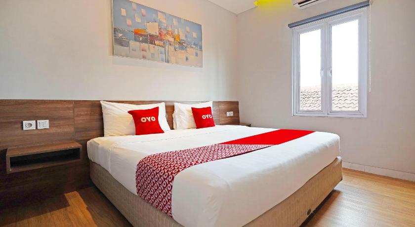 a bedroom with a large bed and a large window, The Regia Dago in Bandung