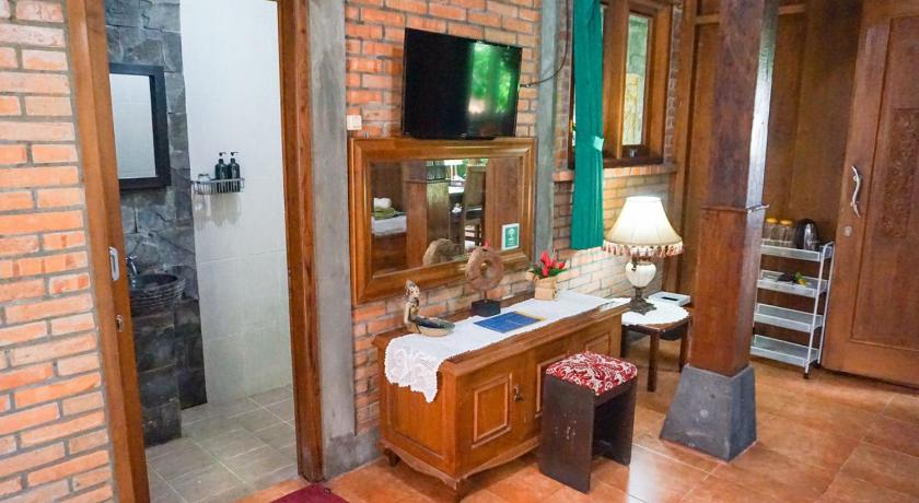 a living room filled with furniture and a tv, Ndalem Suryo Saptono Guest House in Yogyakarta