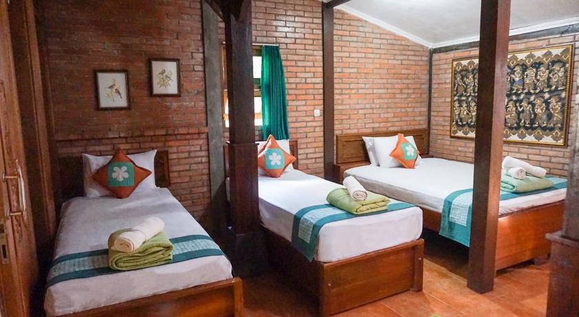 a bed room with two beds and two lamps, Ndalem Suryo Saptono Guest House in Yogyakarta
