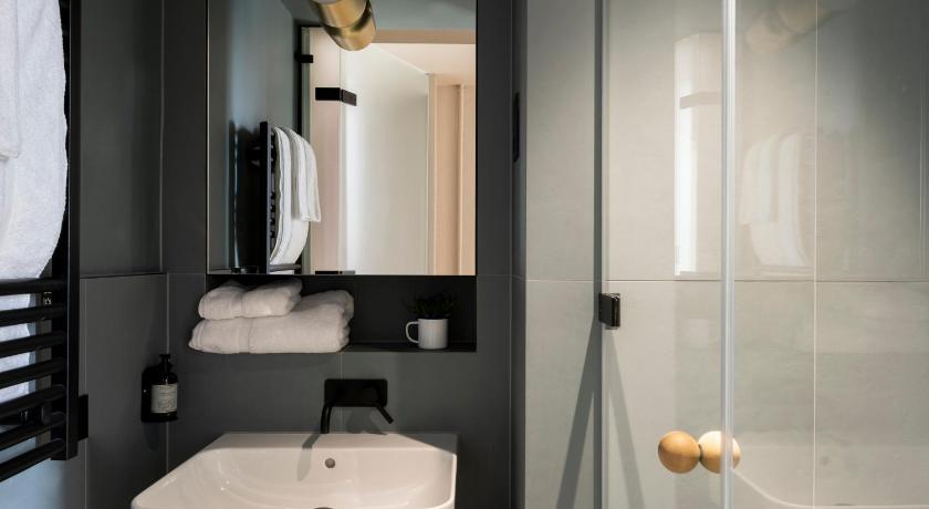 a bathroom with a sink, mirror and toilet, Buckle Street Studios by Locke in London