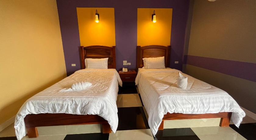 two beds in a room with two lamps on, The Palm Resort Kampeang Saen. in Nakhon Pathom