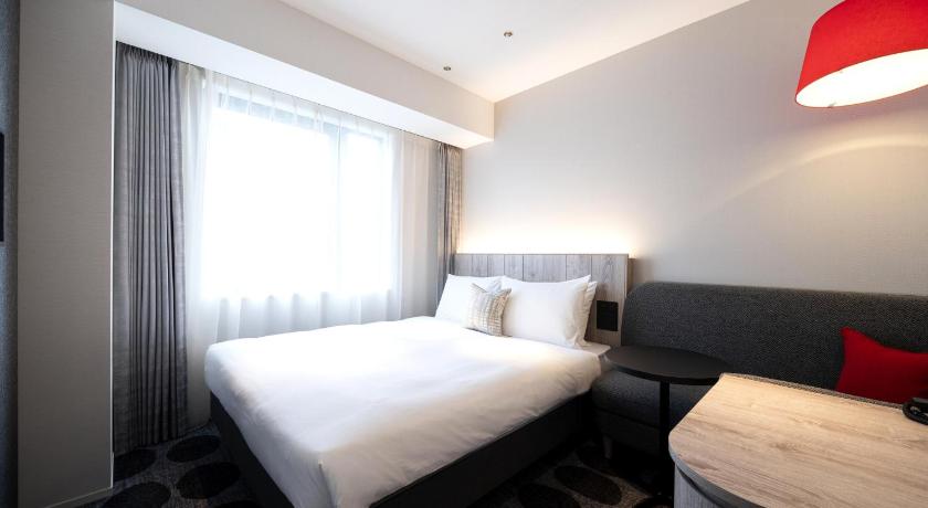a hotel room with a large bed and a large window, Hotel JAL City Toyama in Toyama