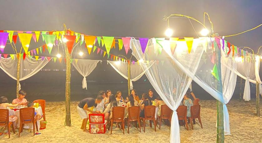 a large group of people sitting at a table with umbrellas, Homestay 368 in Hạ Long