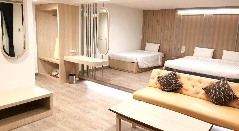 a hotel room with two beds and a table, Sakol Hotel (SHA Extra Plus) in Hat Yai