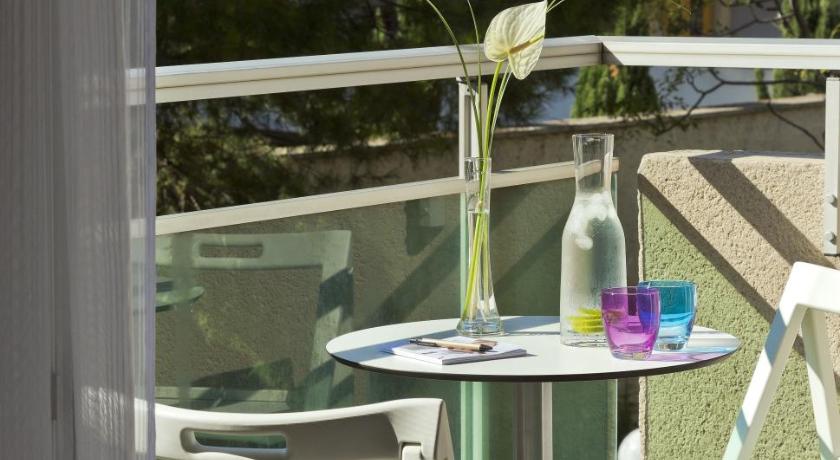 a table topped with a vase filled with flowers, Citadines Castellane Marseille in Marseille