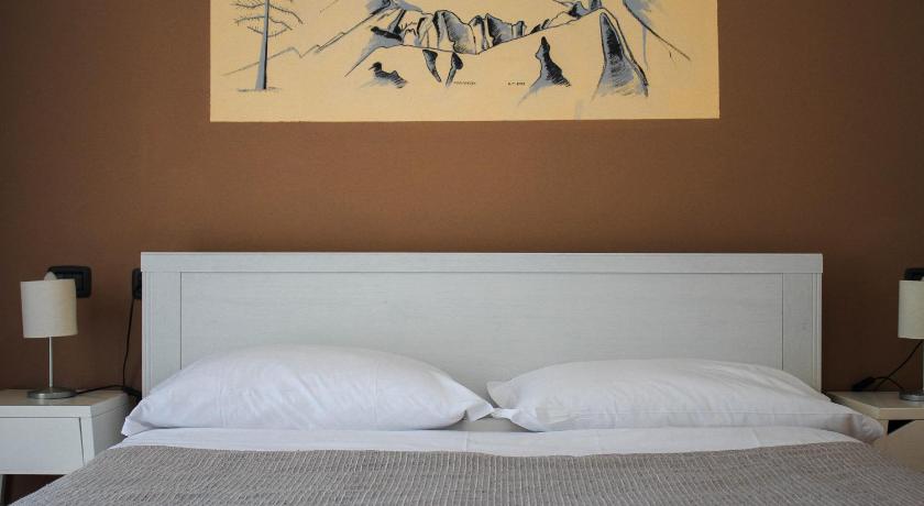 a bed with a painting on the side of it, Hotel Fontaine Bleue in Orta San Giulio