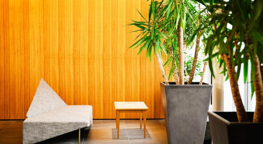 a wooden bench sitting in front of a green wall, Garden Terrace Saga Hotel & Maritopia in Saga