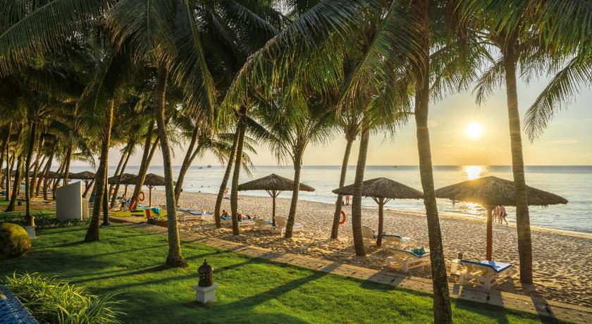 a beach with palm trees and palm trees, L'Azure Resort and Spa in Phu Quoc Island