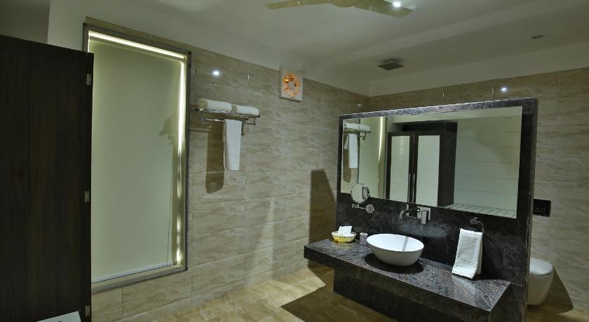 a bathroom with a large mirror and a bath tub, Jhansi Hotel in Jhansi