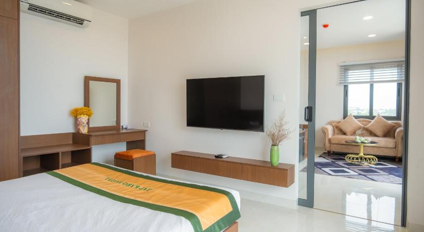 a hotel room with a bed, tv and a desk, JAP KARO HOTEL in Phan Rang – Tháp Chàm (Ninh Thuận)
