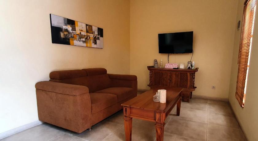 a living room filled with furniture and a tv, Rosseno Villa in Yogyakarta