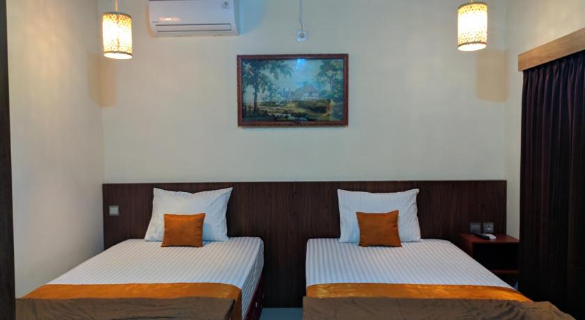 a hotel room with two beds and two lamps, Indah Nusantara in Banyuwangi