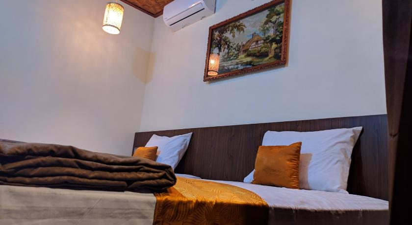 a bed room with a white bedspread and pillows, Indah Nusantara in Banyuwangi