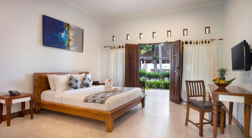 a bedroom with a large bed and a large window, Royal Regantris Villa Karang in Lombok