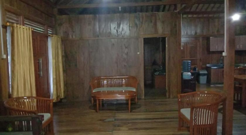 a living room filled with furniture and a wooden floor, Rumah Kayu Sumberrejo in Malang