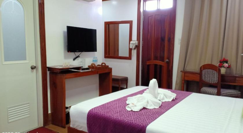 a hotel room with a bed, table and television, CLN Boutique Hotel in Tacloban City