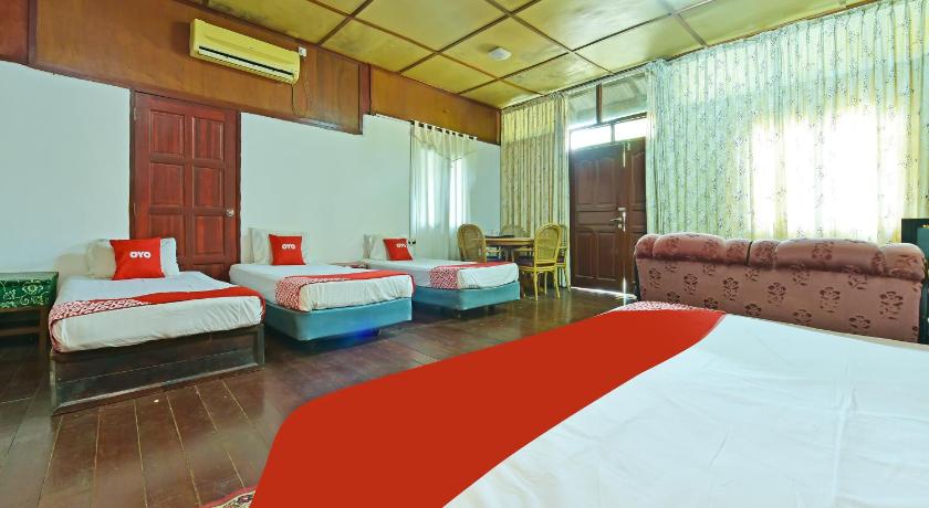 a hotel room with two beds and a couch, OYO 90595 Pelangi Beach Resort Cherating in Cherating
