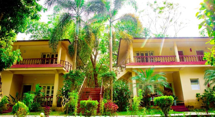 a large house with a large window and palm trees, Hotel Parkland in Chitwan