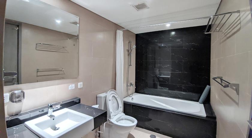 a bathroom with a sink, toilet and bathtub, Sakura Park Hotel and Residence in Cikarang