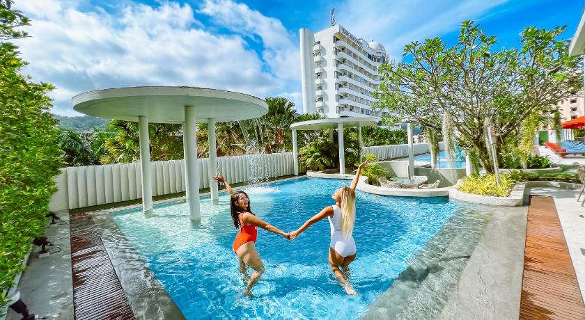 two young children playing in a pool in front of a building, Ramada by Wyndham Phuket Deevana Patong (SHA Plus+) in Phuket