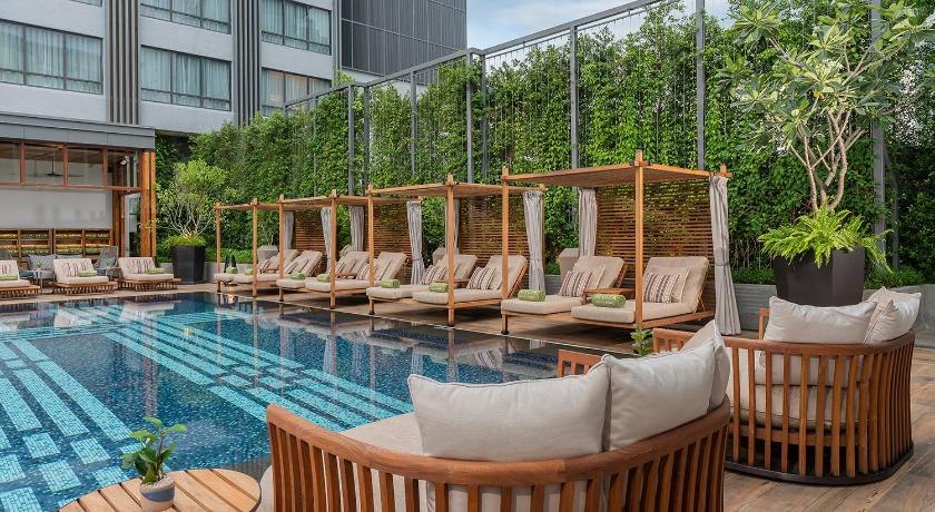 a lounge area with chairs, tables, and umbrellas, Melia Chiang Mai in Chiang Mai